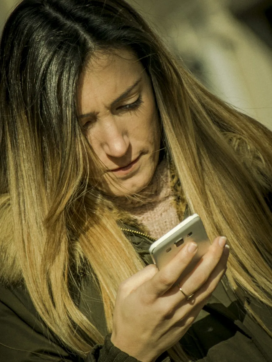 Blonde woman concentrating on a smartphone screen